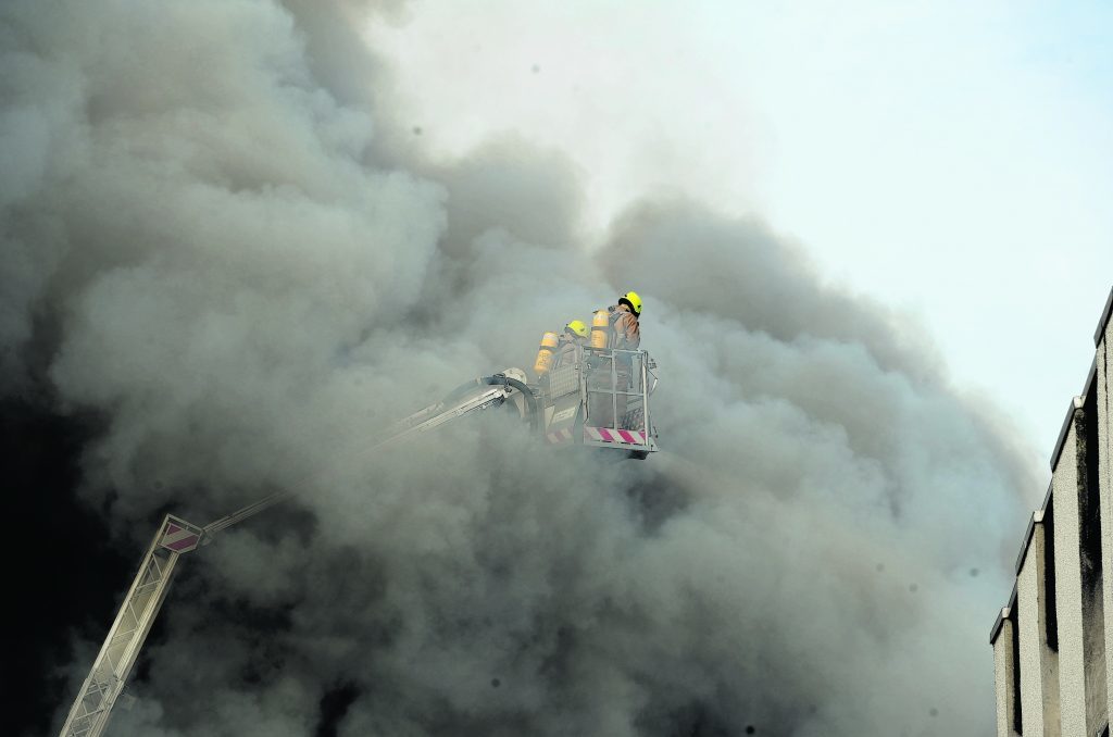 A firefighter immersed in thick smoke during the blaze.