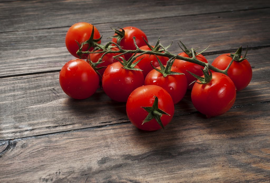 Fresh cherry tomatoes on wood background