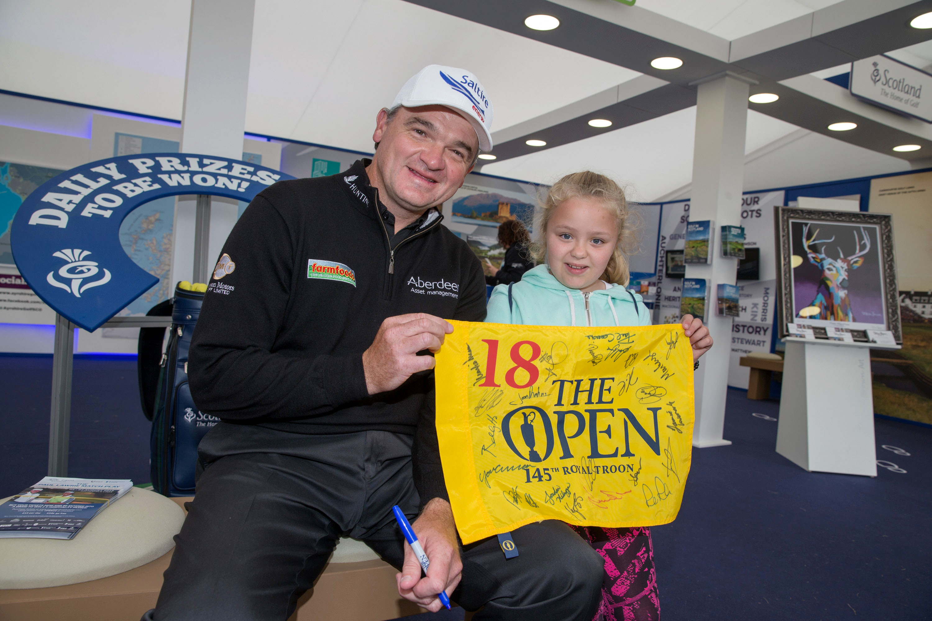 Paul Lawrie with Demi Richardson after signing her Open flag at the Scotland Home of Golf Stand.
