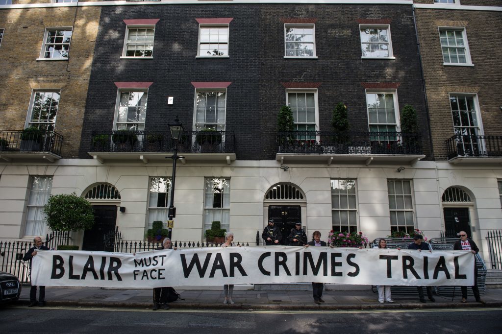 Protesters hold up a banner outside Tony Blair London residence on the morning of the Chilcot Report's release.