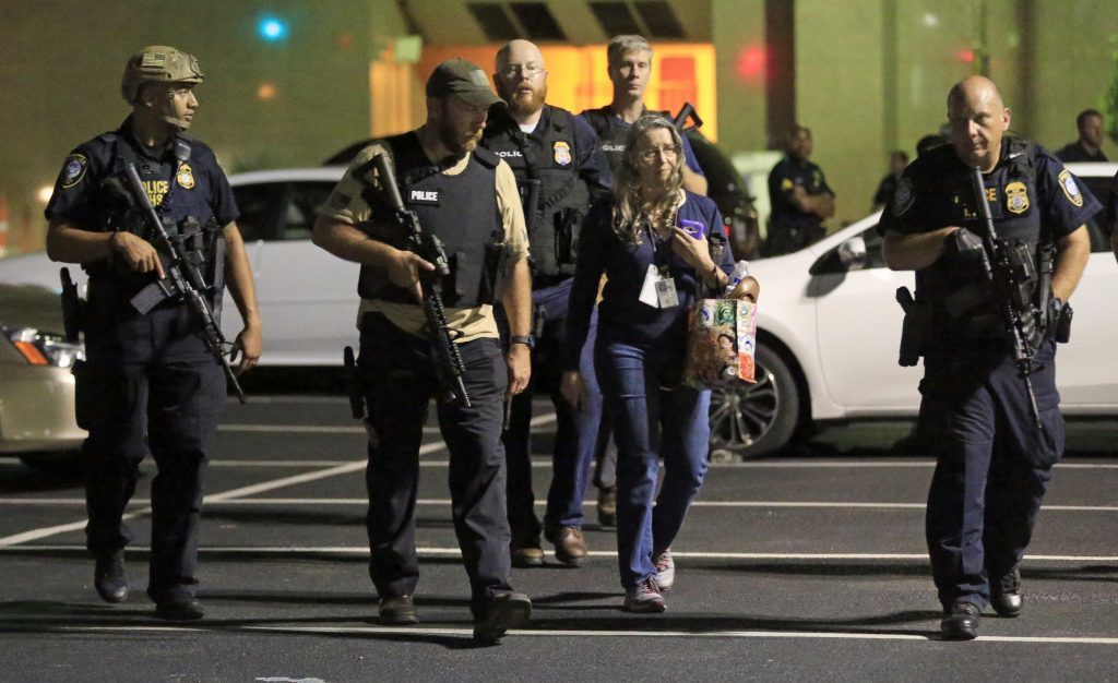 Police officers escort a woman near the scene.
