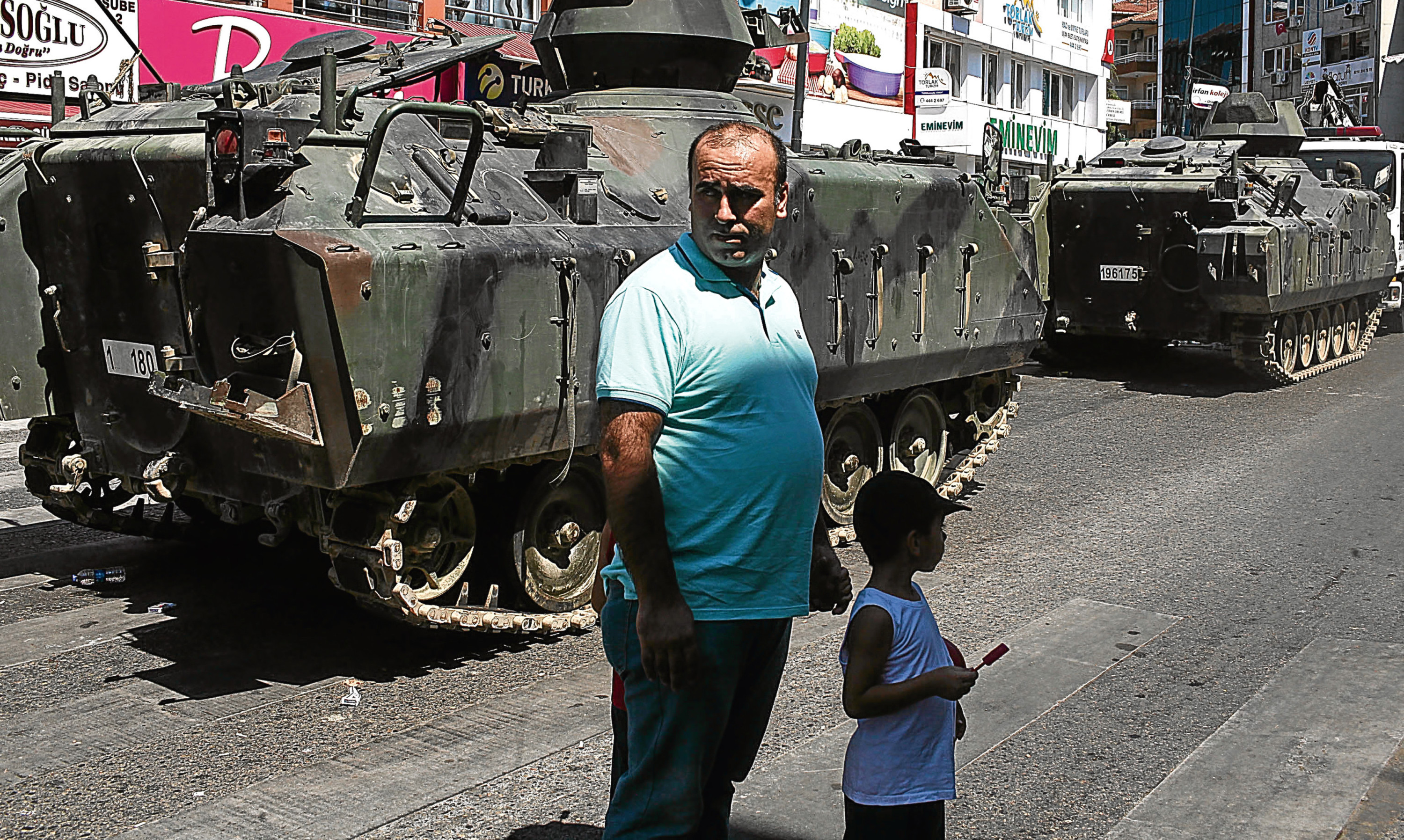 A Turkish man and his son stands near an abandoned armoured vehicle in the Uskudar district of Istanbul.