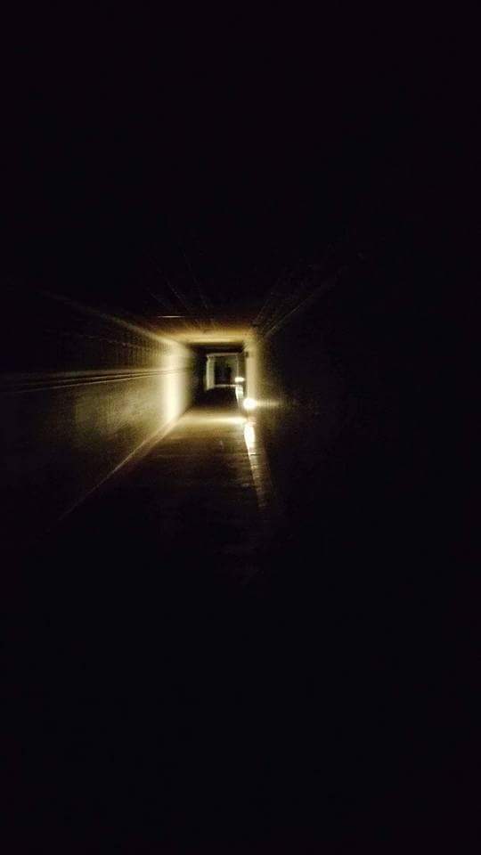 Ghostly figures can be seen at the end of the corridor.