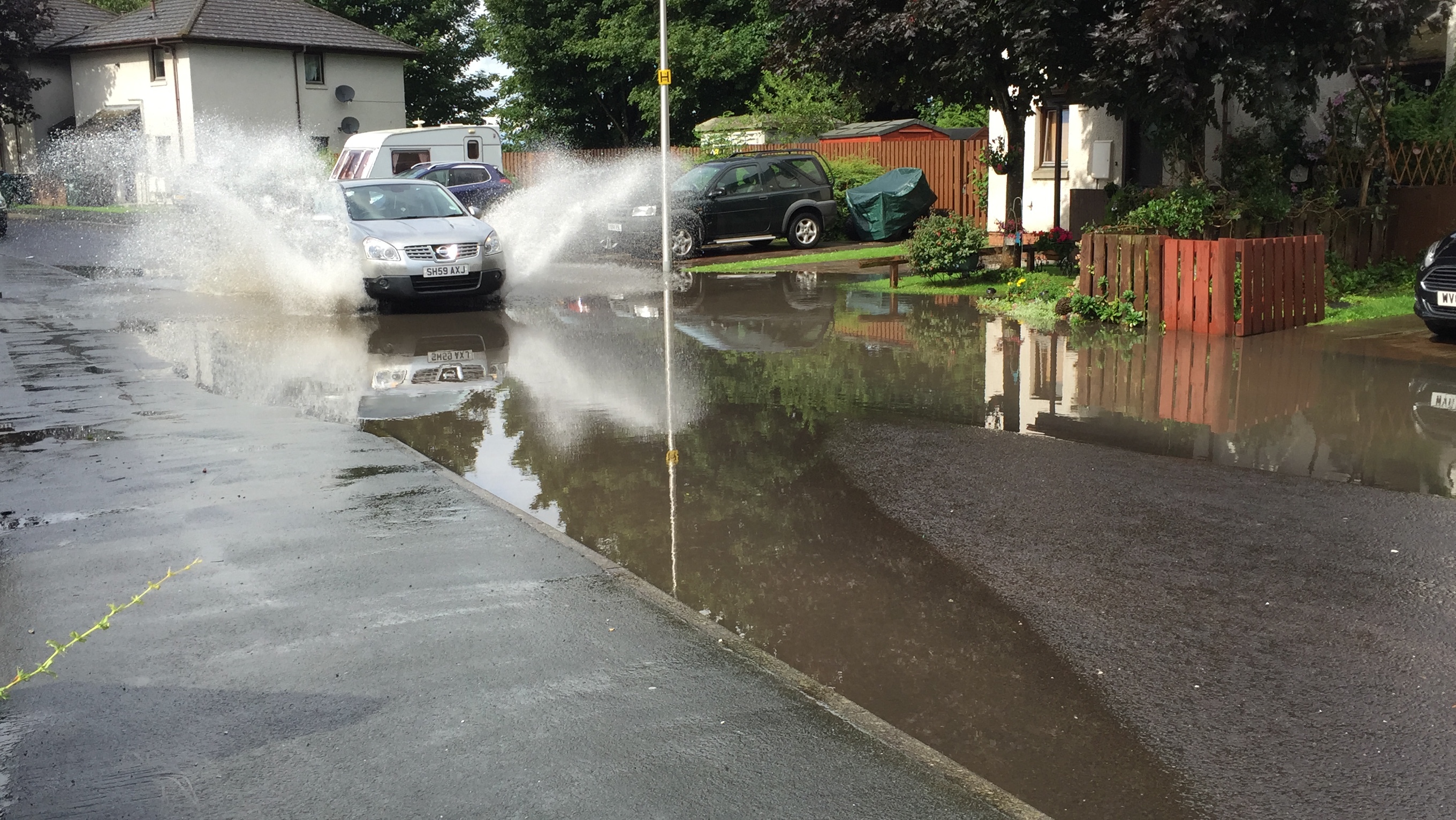 A car drives through the flooding on Cromlix Road.