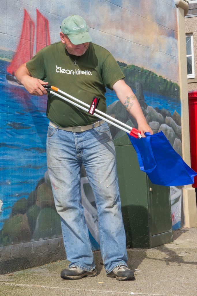 Volunteer Colin Pentland tackles litter on Mitchell Street.