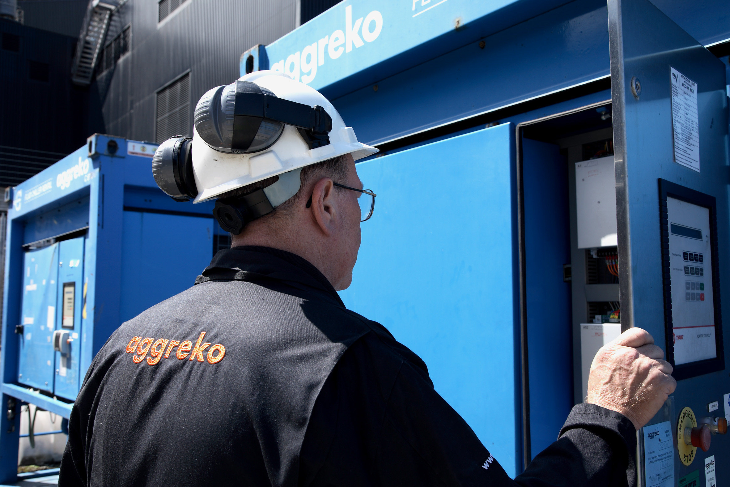 An Aggreko technician checks a power unit