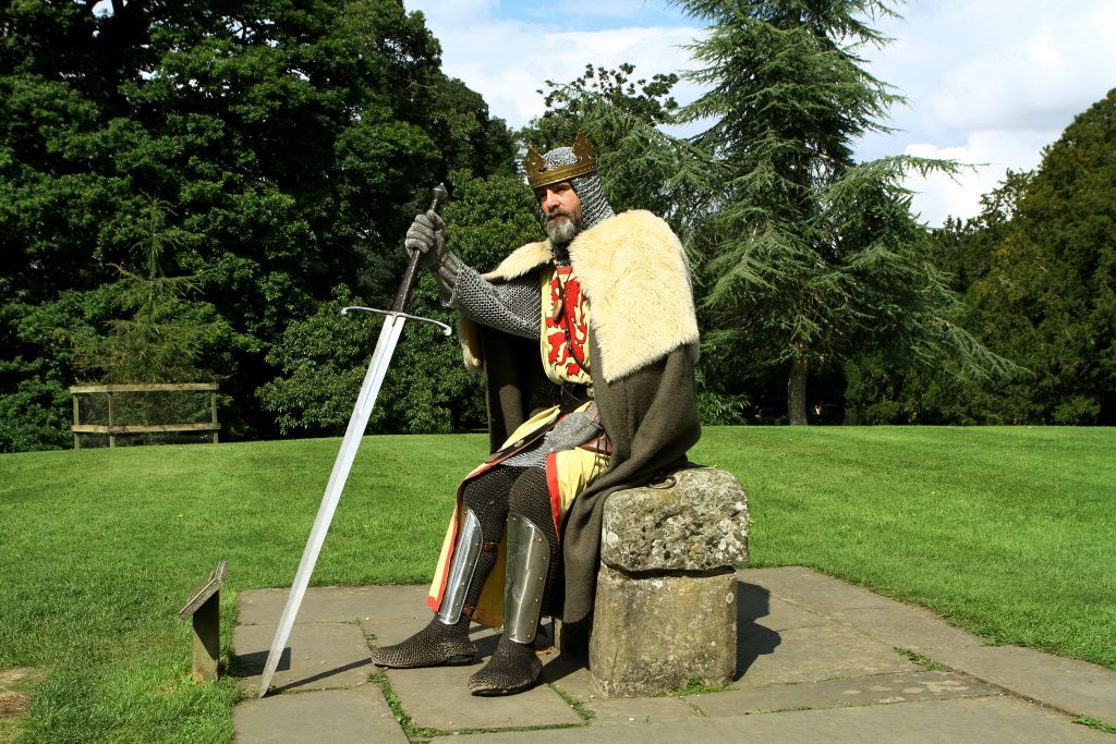 King Robert The Bruce, aka Brian McCutcheon, sitting on a Stone Of Destiny replica.