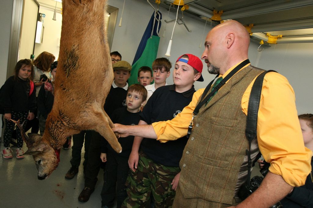 Bruce Cooper showing one of the deer hanging before going to the game dealer.