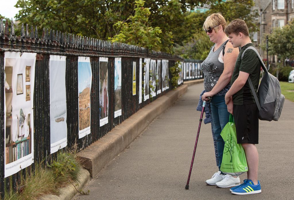 Wendy Clive and Scott Pearson, from Kirkcaldy, view the Document Scotland exhibition on the railings of The Scores in St Andrews - one of the 18 exhibitions in the inaugural St Andrews Photography Festival.