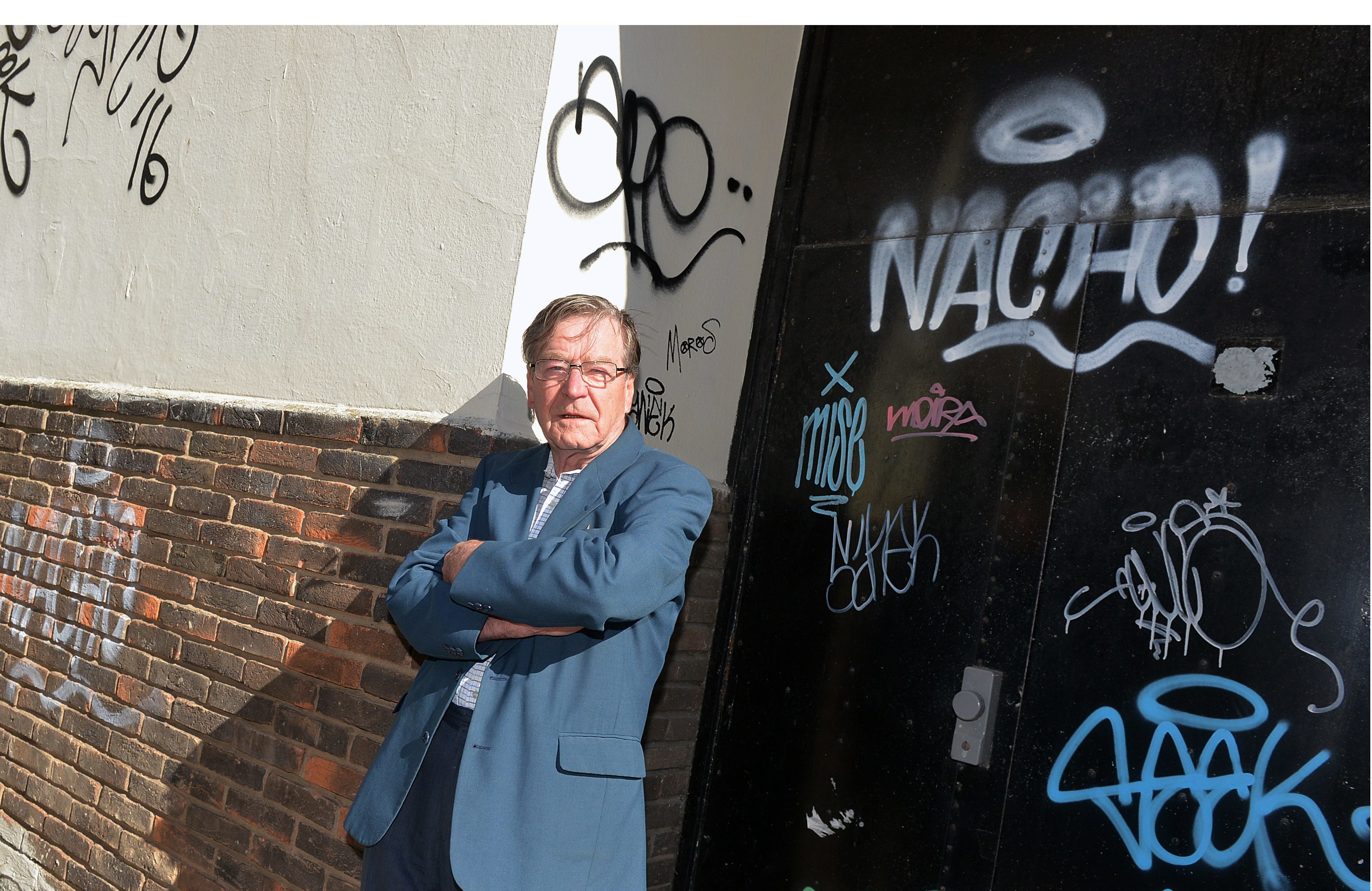 David Henderson, chair of Kirkcaldy West Community Council, next to graffiti in Kirkcaldy town centre.