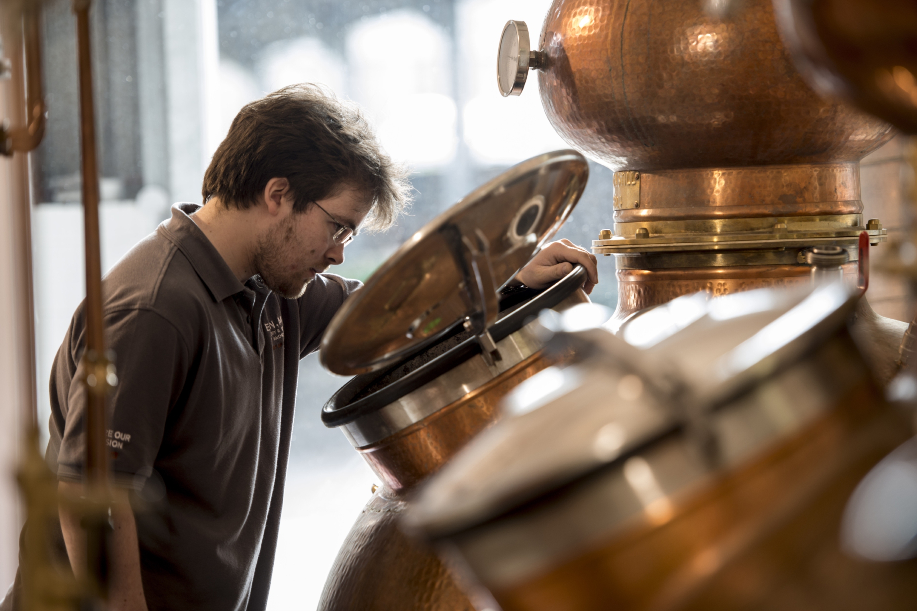 Scott Ferguson, head distiller at Eden Mill, inspects copper still.