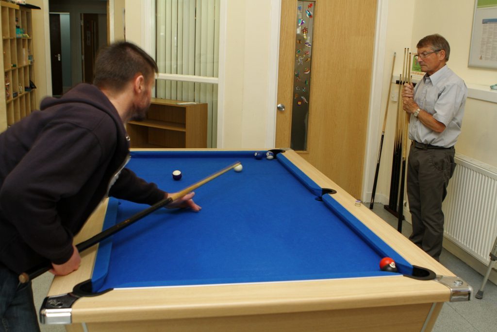 One of the service users having a game of pool at the Havilah Project in Arbroath.
