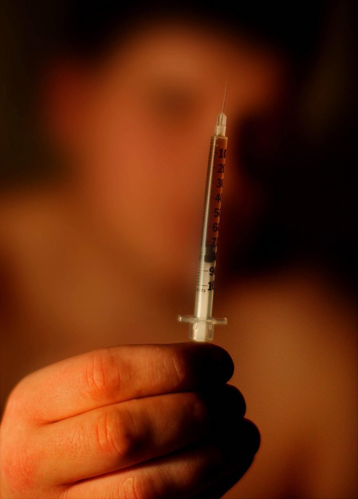 An addict holds up a needle before injecting heroin in the town of Portlaoise, Co Laois, where outreach workers believe up to 600 users could be taking heroin behind closed doors.