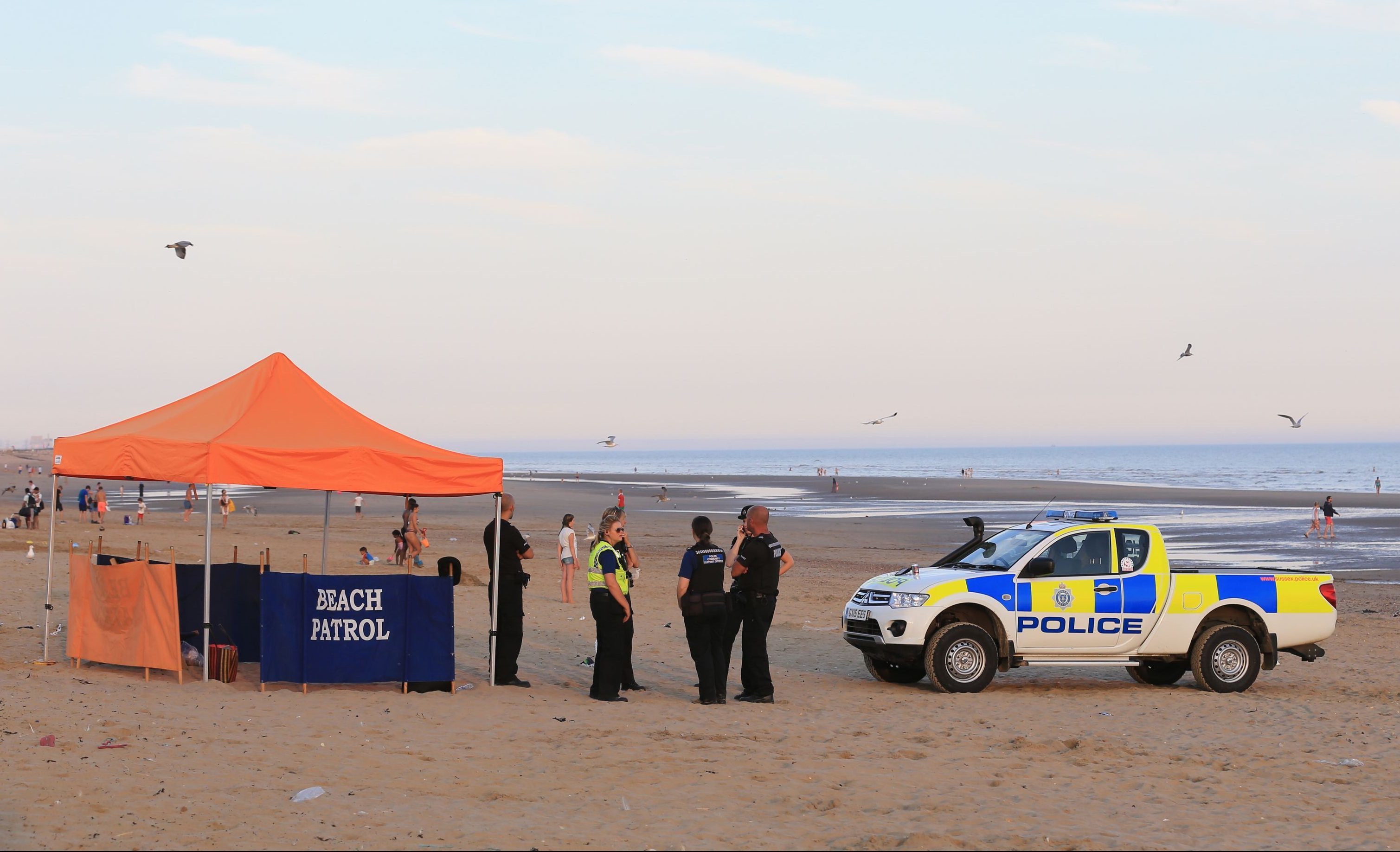 Police officers on Camber Sands near Rye, East Sussex.