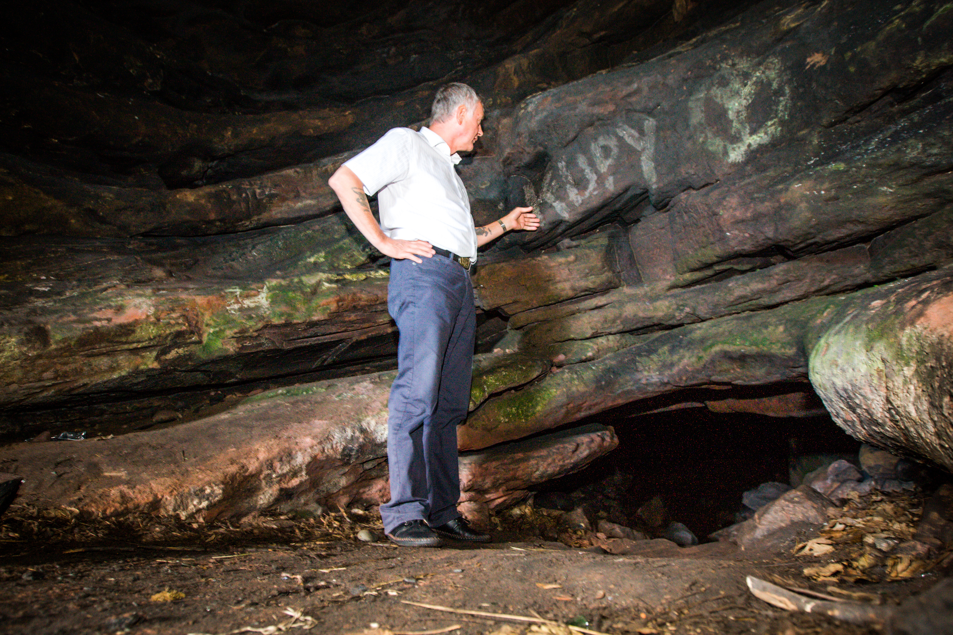 Councillor Tom Adams inspects recent damage to the ancient carvings.