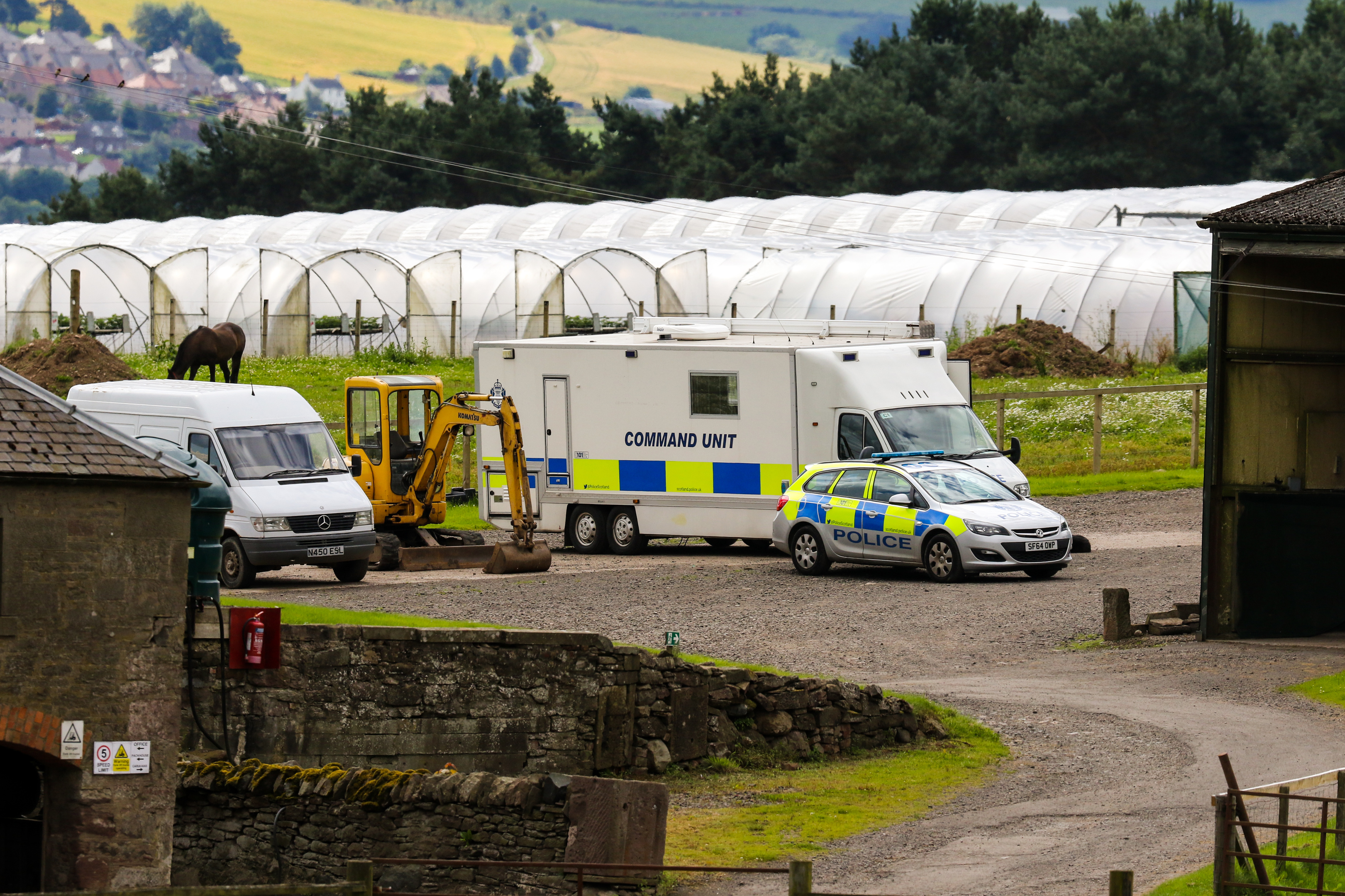 Police vehicles at the scene at Mains of Errol Farm, Errol, on Monday.