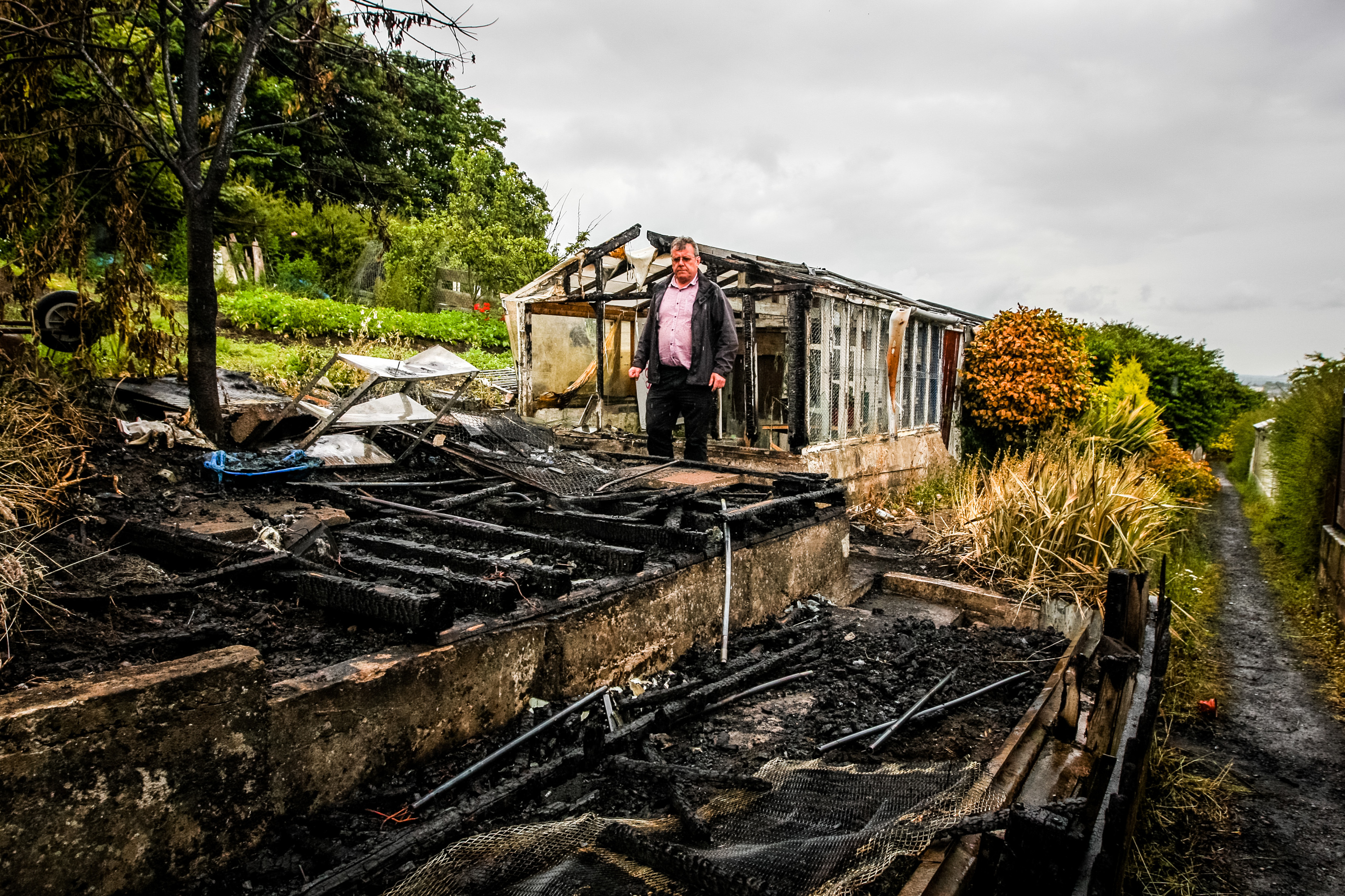 Gordon Robbie (chairman of  Kinnaird Garden Association Allotments) inspects the damage to the burnt out wreck of a shed.