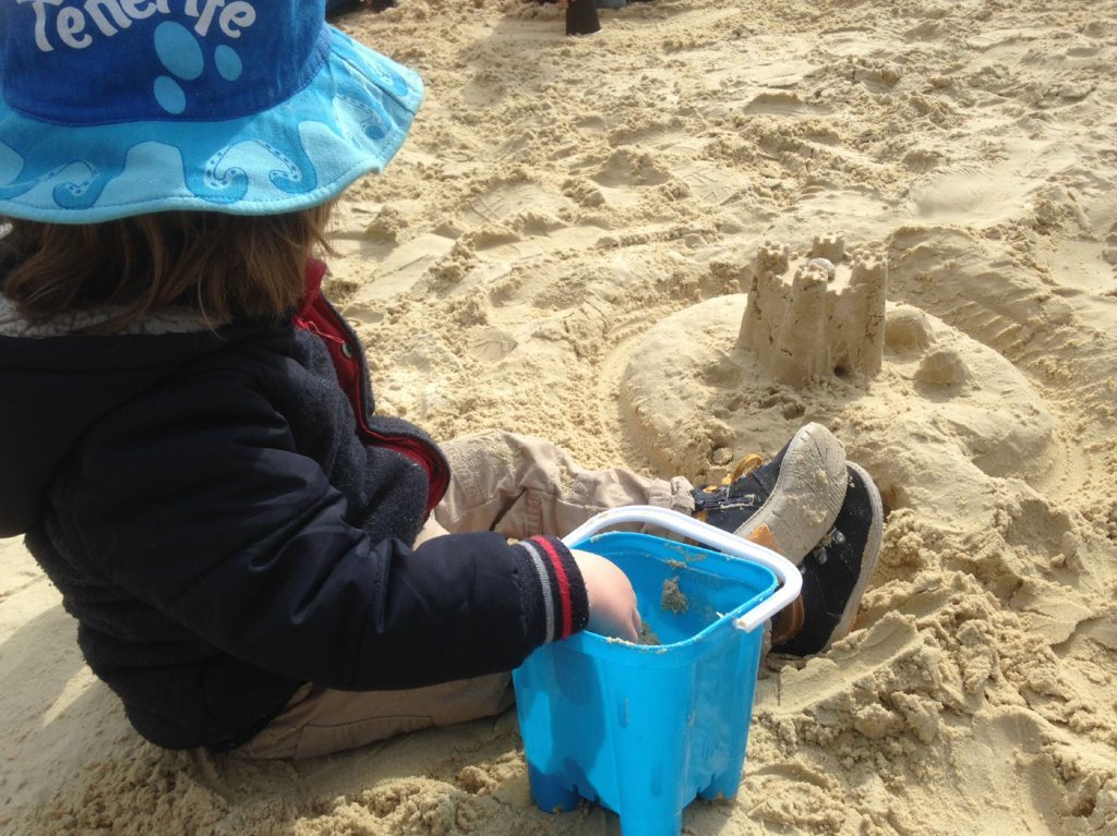 Ollie building sandcastles in the playground's sandpit. 