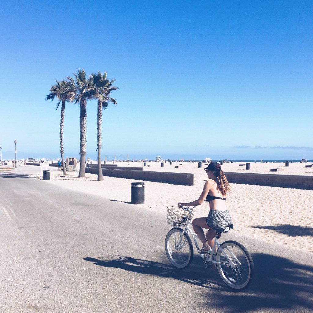 Lisa Haynes cycling along Huntington Beach boardwalk. 