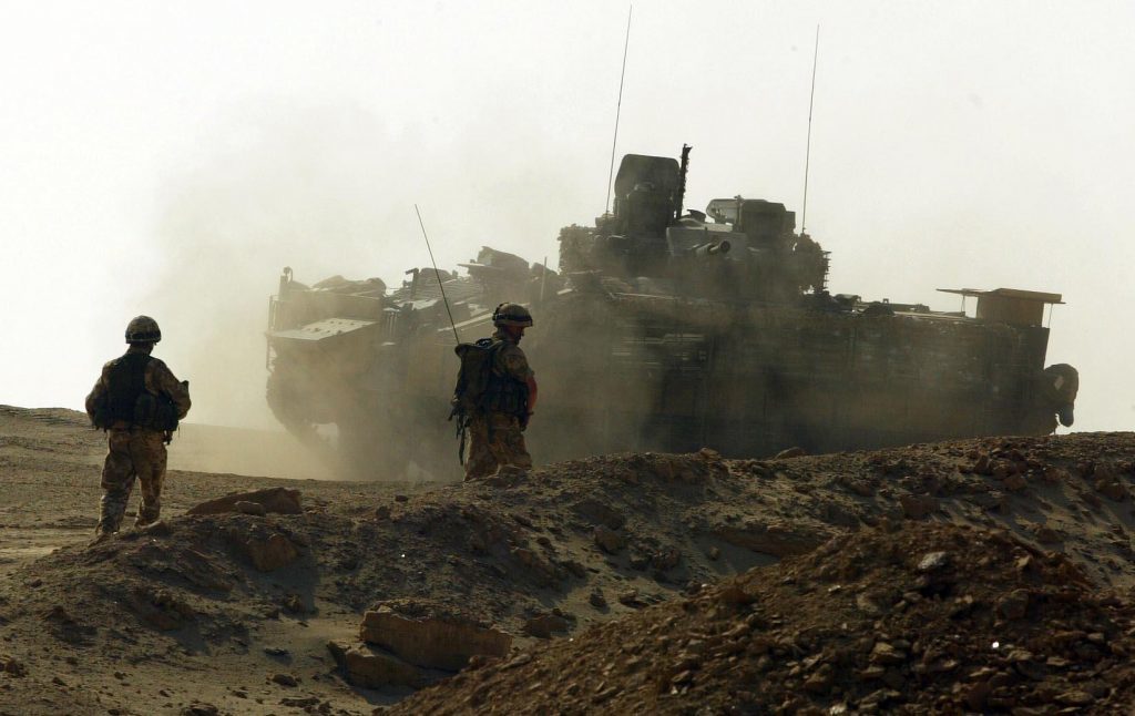 Soldiers from A company of the 1st Battalion Black Watch move back to their Warrior armoured vehicle in 2004 after community patrolling through the area of Ahmed Al Ahamadi near Camp Dogwood. 