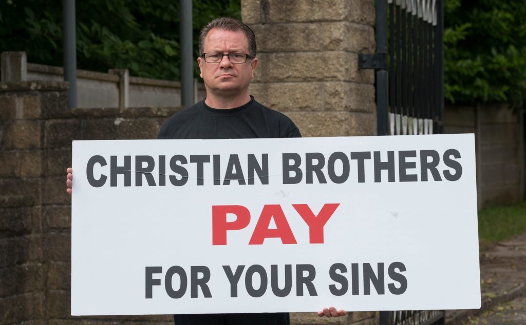 Dave Sharp protesting with a banner outside the Christian Brothers premises of Woodeaves, Wicker Lane, Hale Barns, Altrincham, Cheshire,  on Thursday  June 23 2016