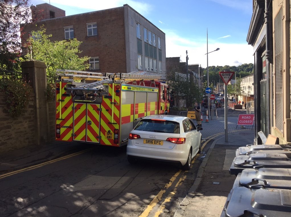 A fire engine and vehicle battle for space on Lochee's Bright Street as roadworks continue.