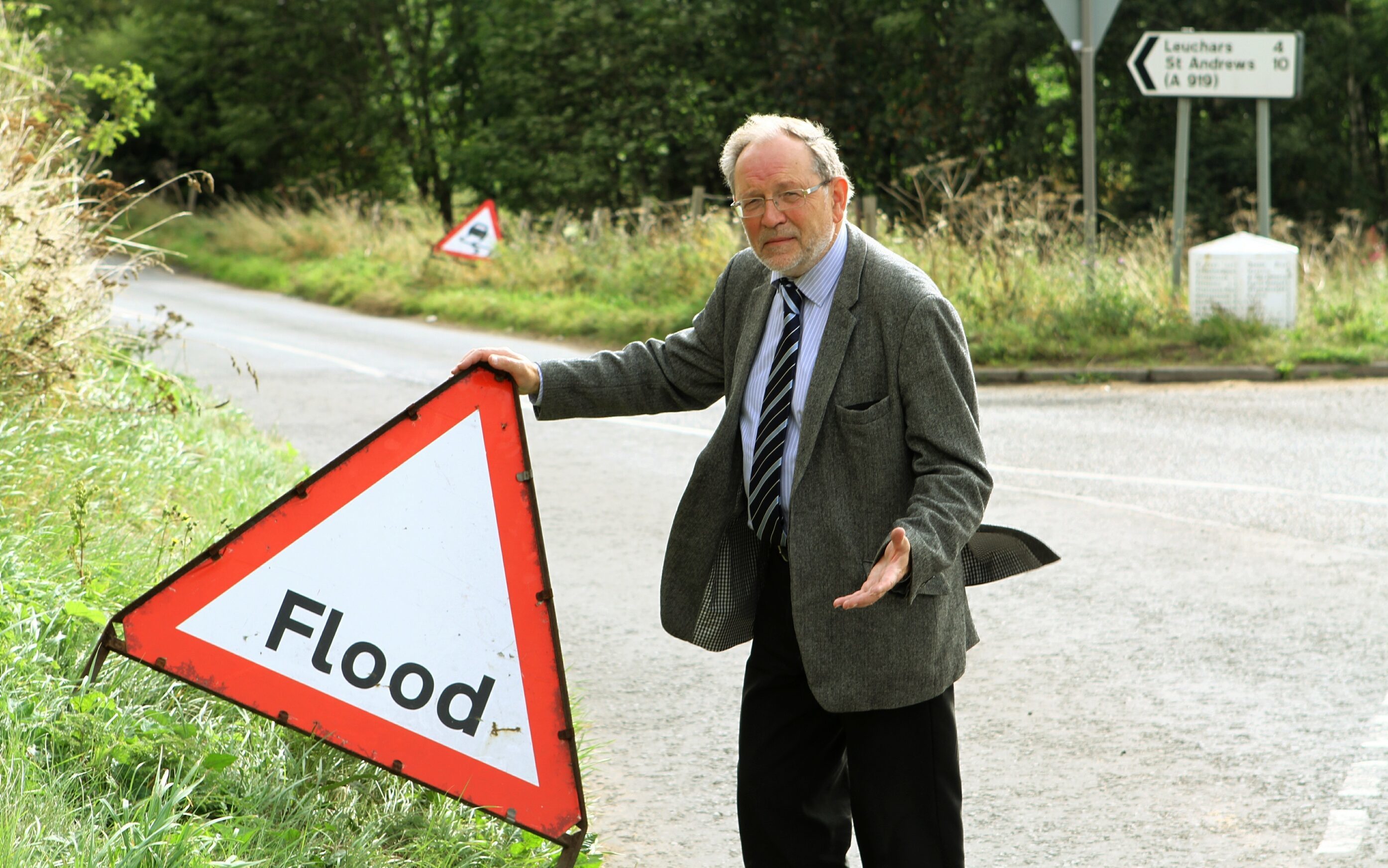 Tim Brett beside one of the leftover flood signs near Wormit