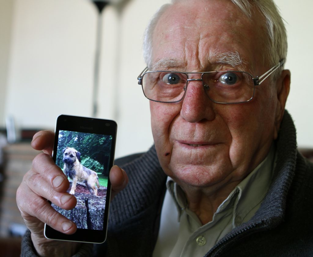 Leonard Ormond with a photograph of his dog Rosco.