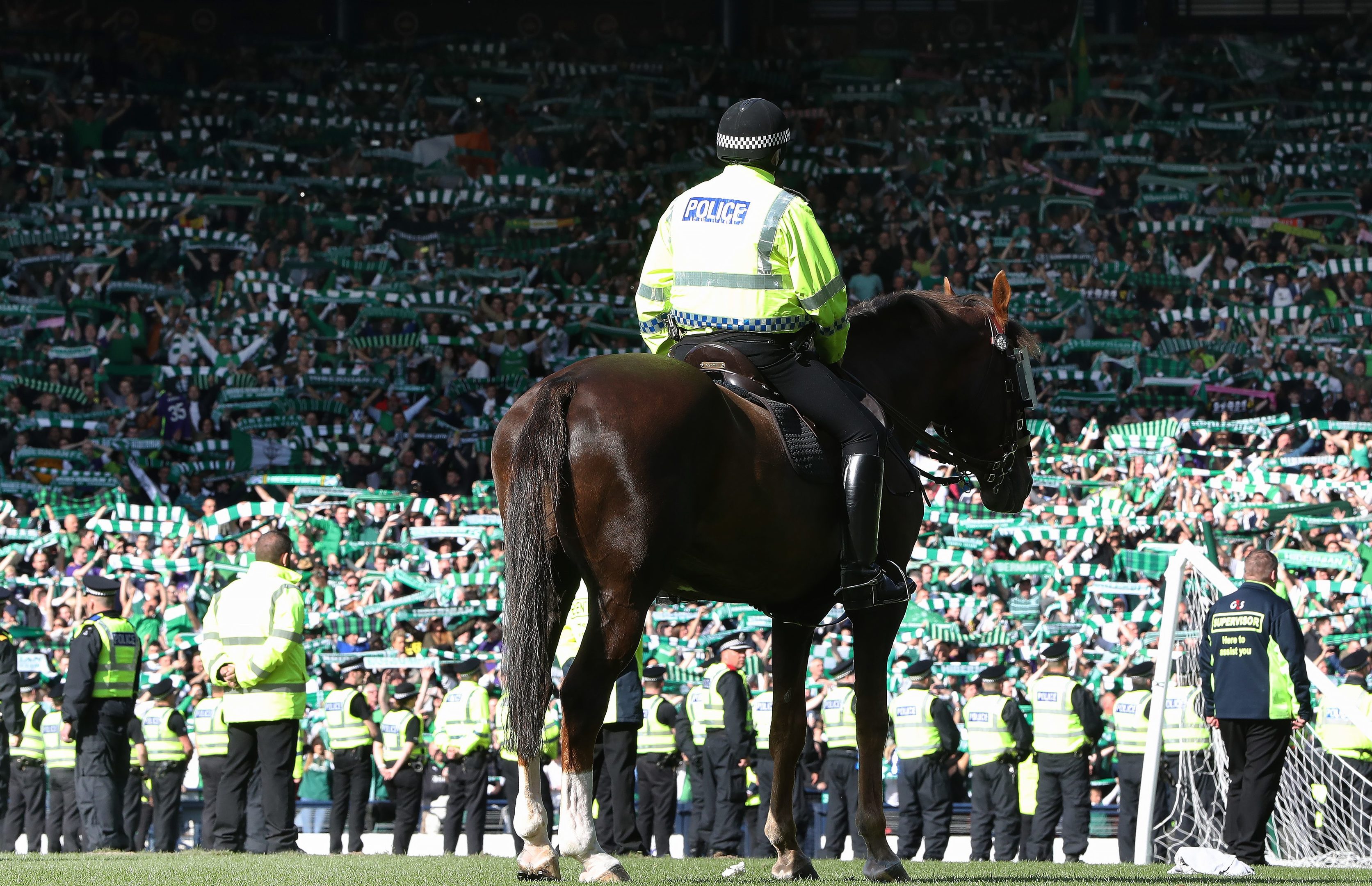 A mounted police officer looks on as Hibs fans celebrate during the Scottish Cup Final between Rangers and Hibernian at Hampden Park on May 21, 2016 in Glasgow.