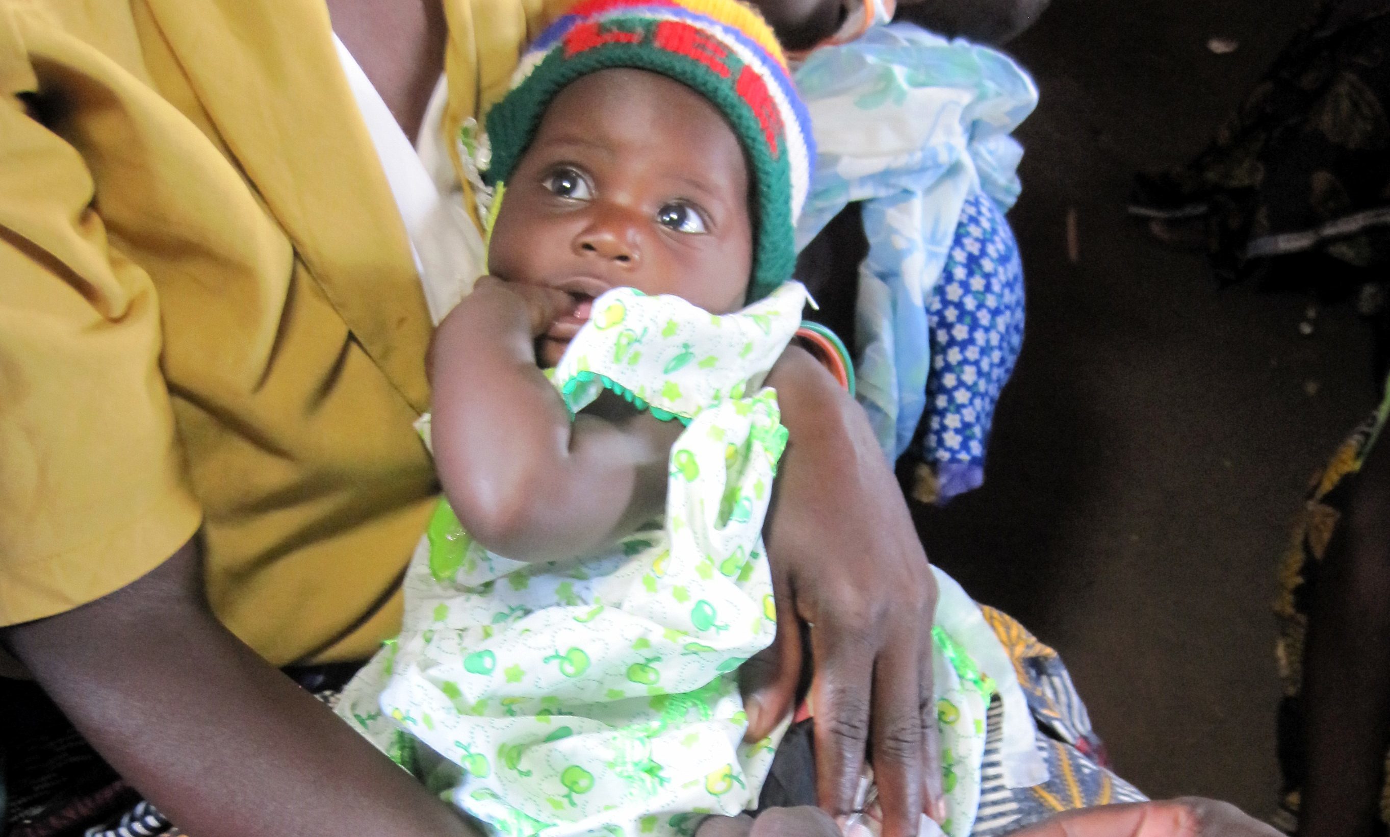 A mother holds her child as they are vaccinated by health workers in Malawi.