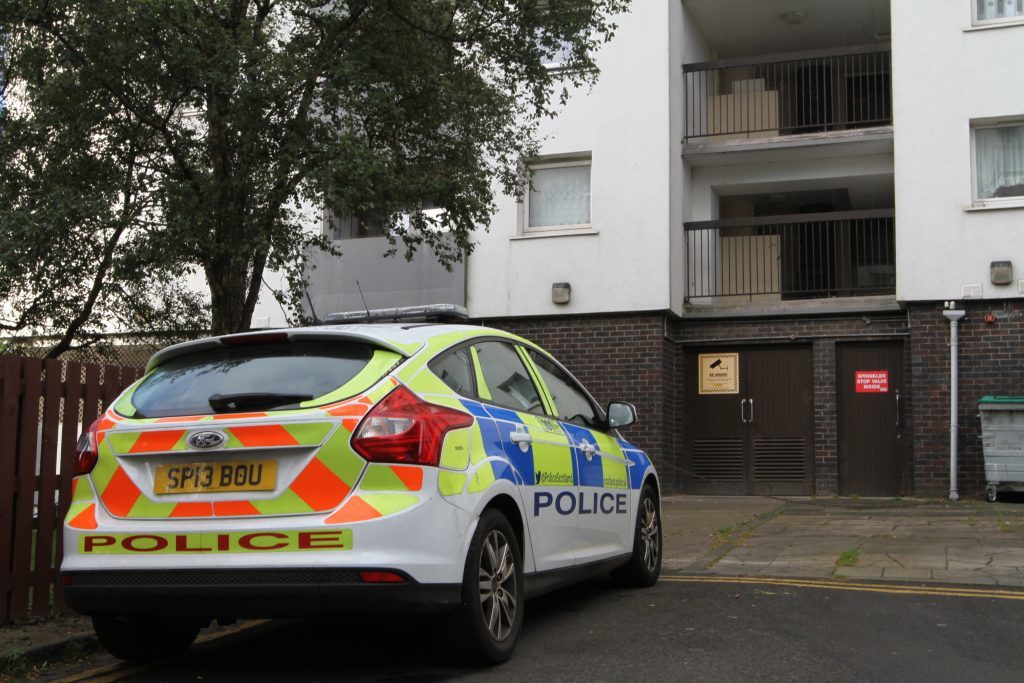 Police presence outside the building where the tragedy occurred.