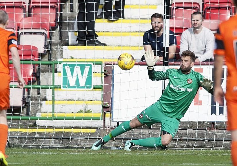 Cammy Bell makes his first penalty save from Gavin Reilly.