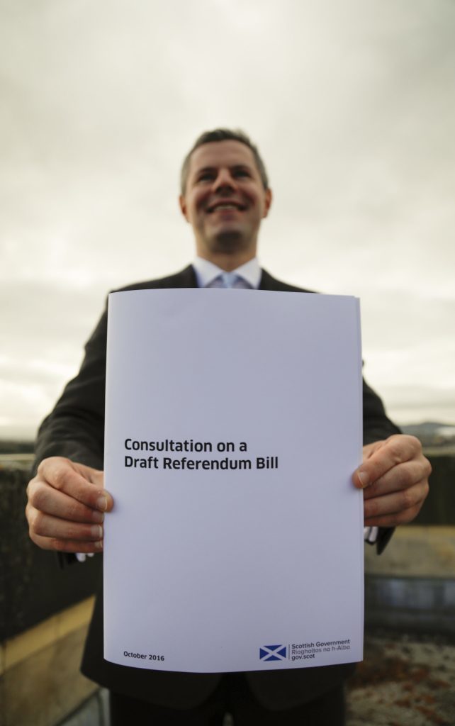 Cabinet Secretary for Finance and the Constitution Derek Mackay with the document.
