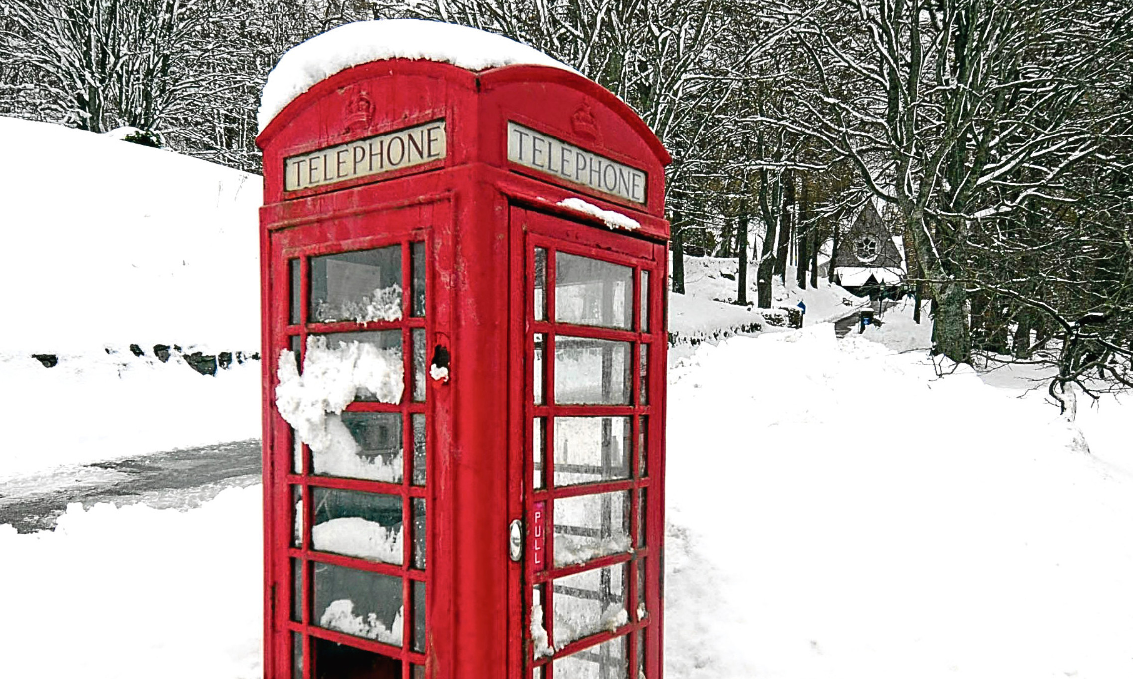 Out in the cold. A snow entrenched phonebox near the Balmoral estate, Aberdeenshire. Could it and many others be an endangered species?