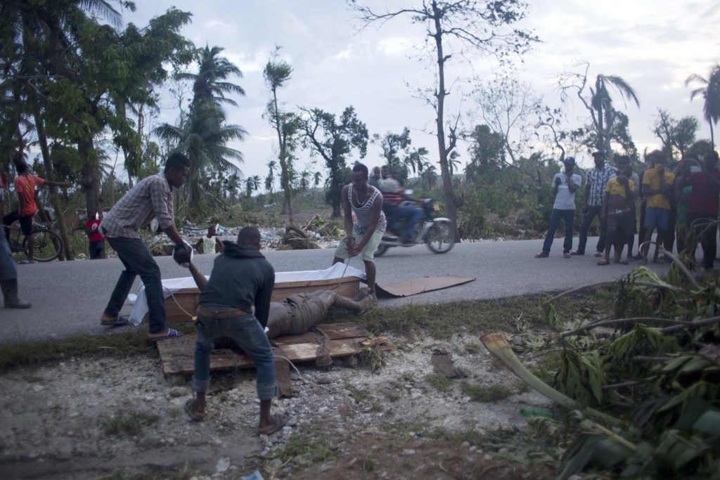 Residents try to recover the body of victim of Hurricane Matthew in Cavaillon, a district of Les Cayes, Haiti. 