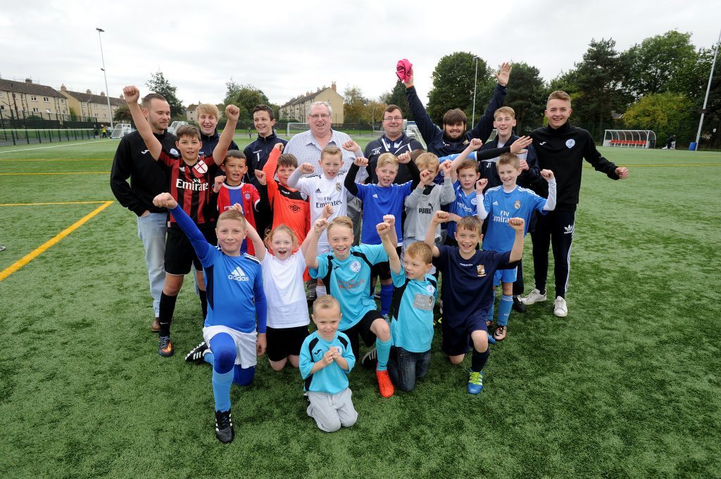 Ken in the midst of youngsters and community coaches on the Seven Acres 3G pitches he helped make a reality.