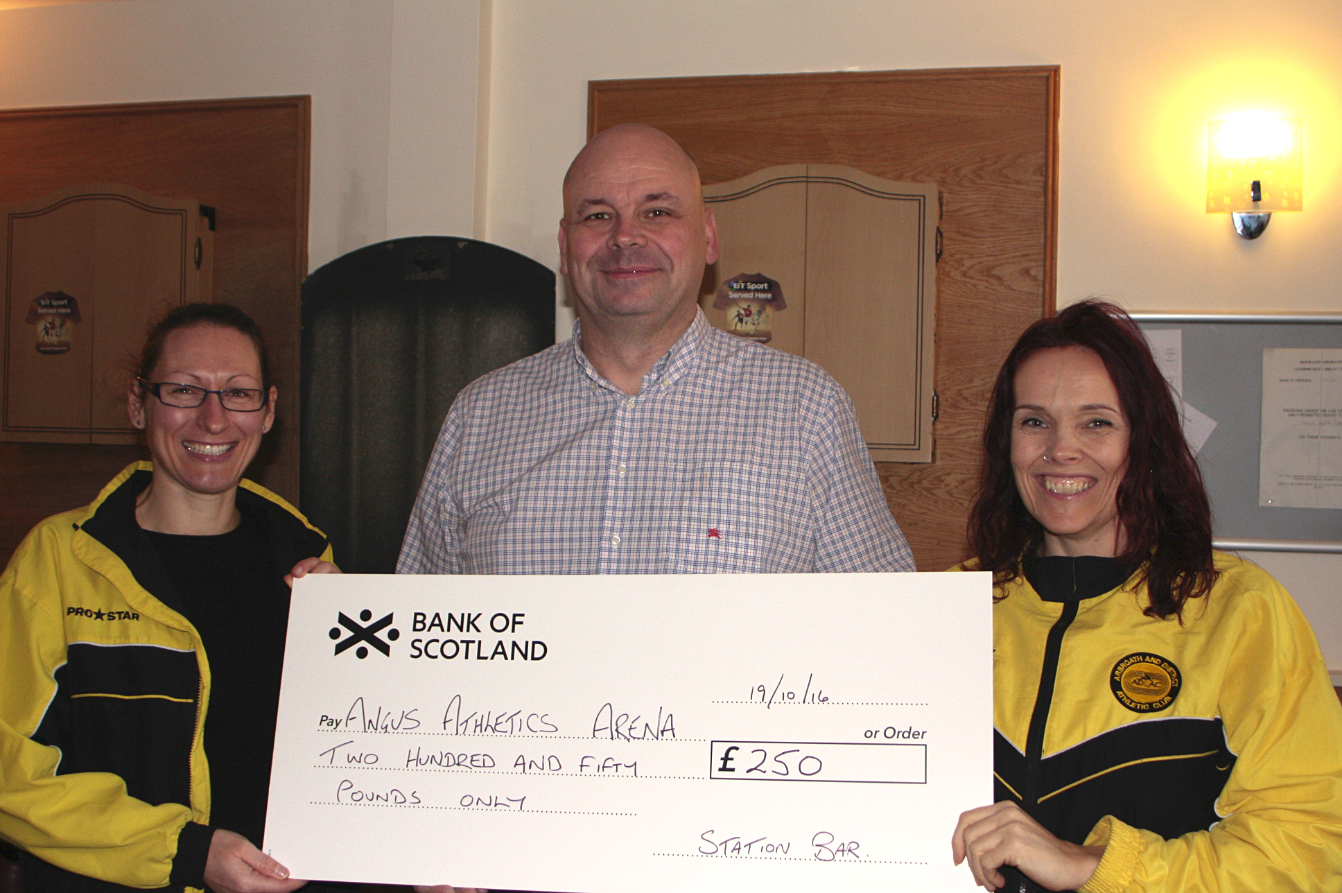 Angus Athletics Arena campaign vice chair Cherise Whamond (left) and treasurer Karen Kelly (right) receiving a donation to the campaign from Station Bar proprietor Paul Cook.