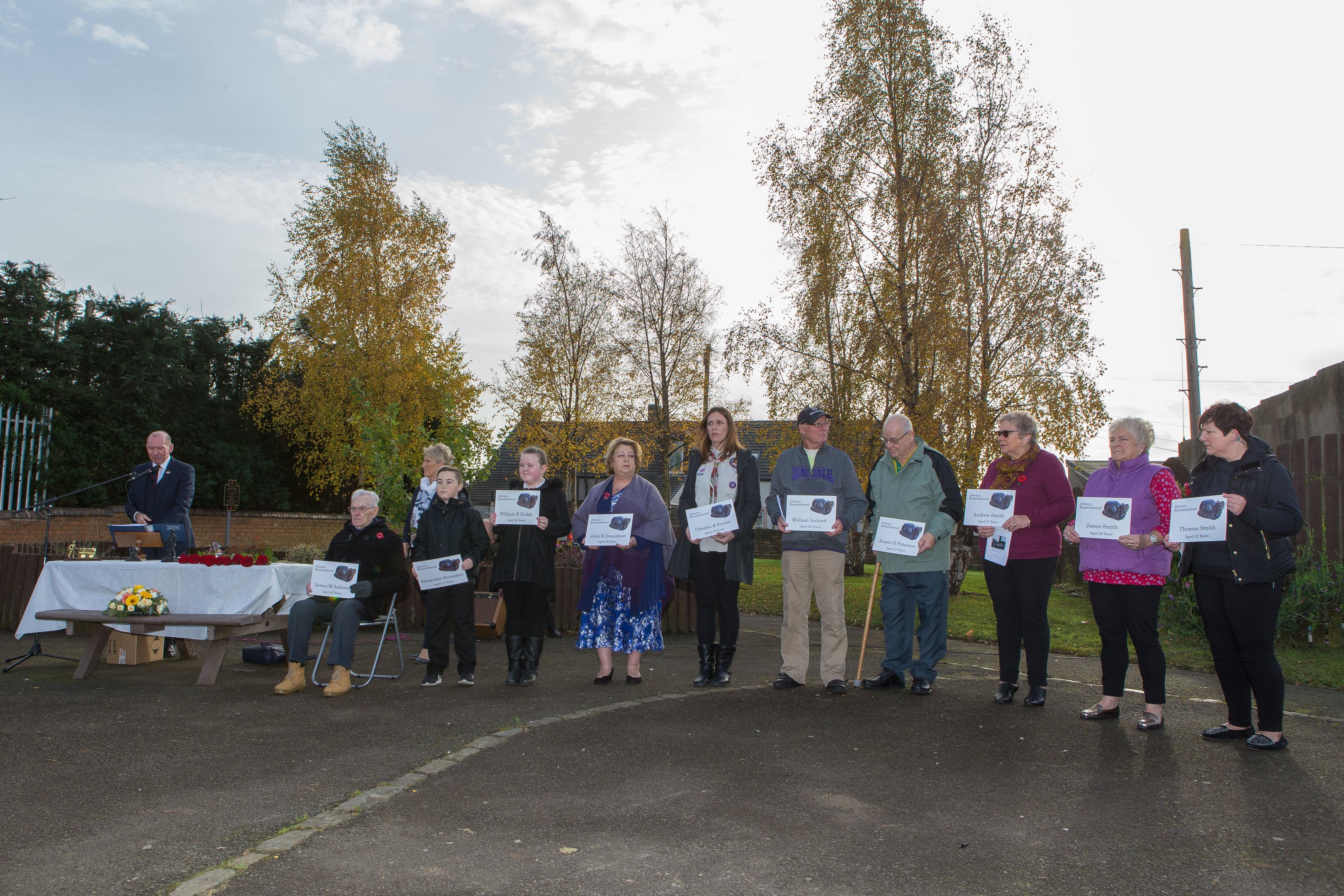 The memorial service in Bowhill Community Garden led by John Gilfillan and attended by locals. Members of the public held plaques with the names of the dead miners on them.