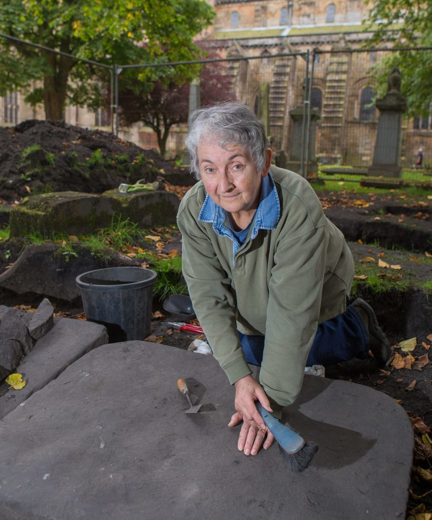 Sue Mowat uncovering gravestones. 