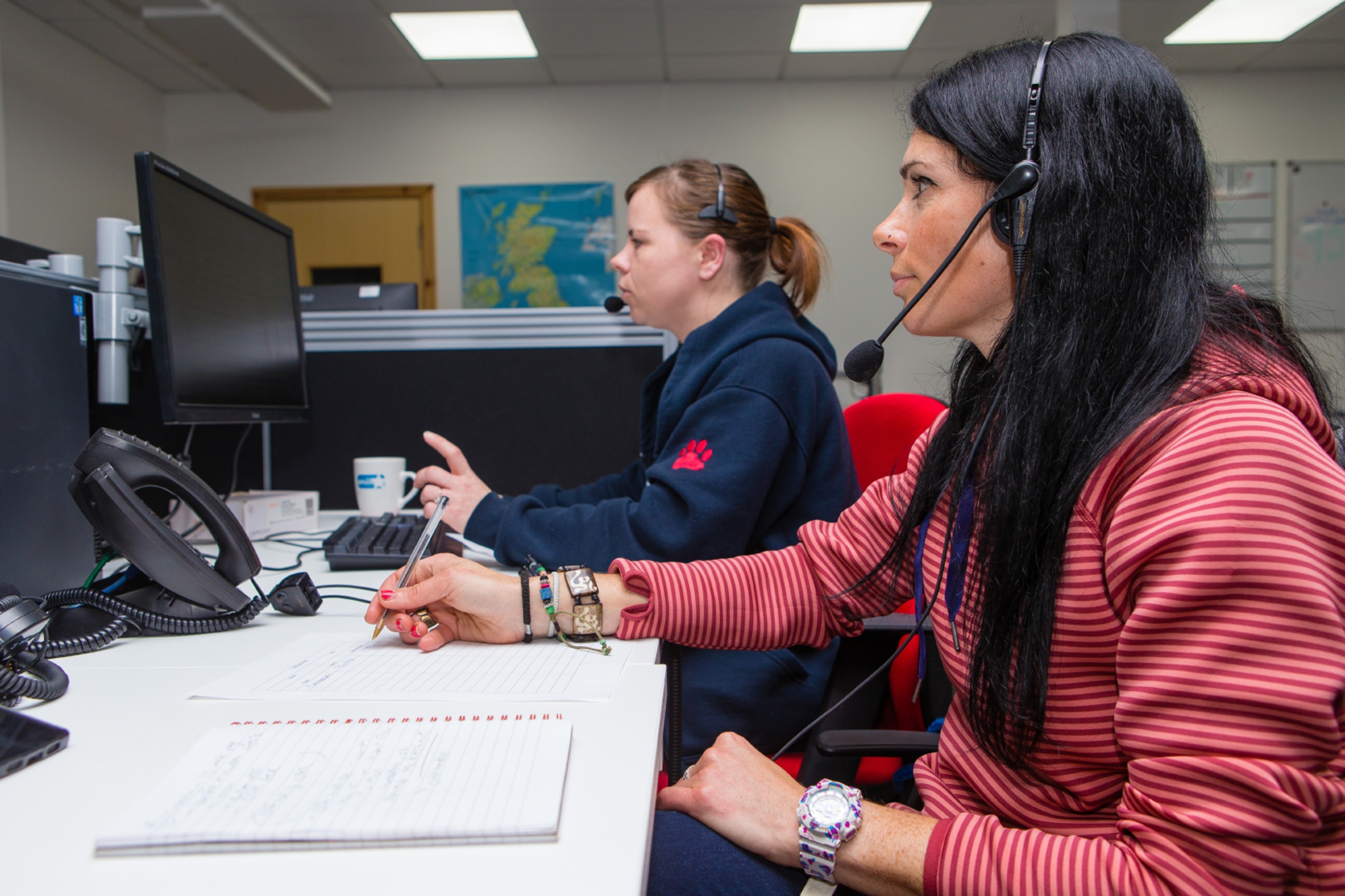 Gayle Ritchie listens in while call handler Heather McKechnie advises a worried pet owner.