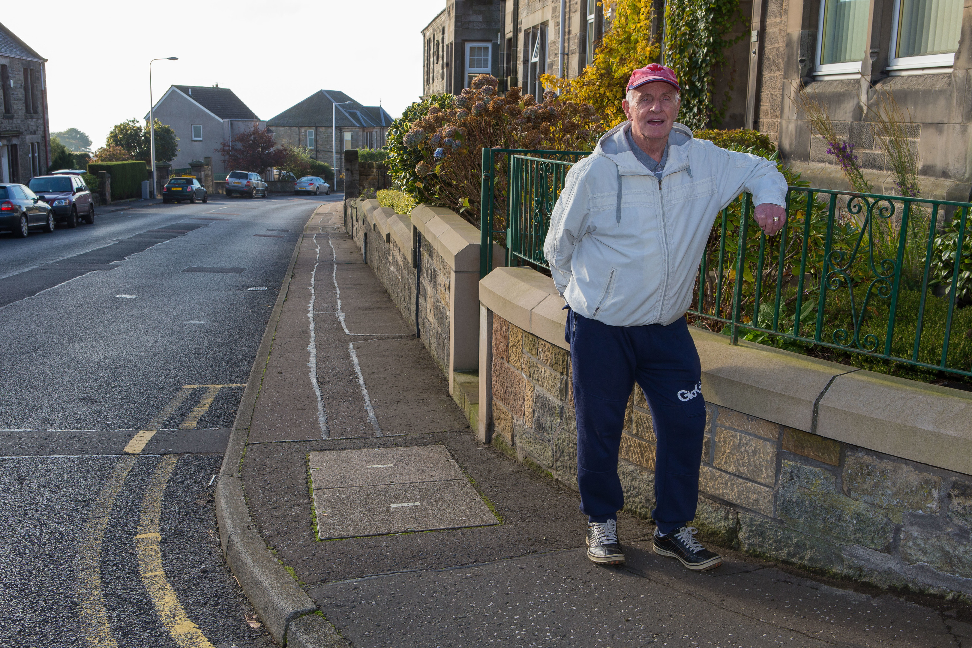 Dysart resident Tom Nisbet at his wall, that been rebuilt several times after cars crashed into it.