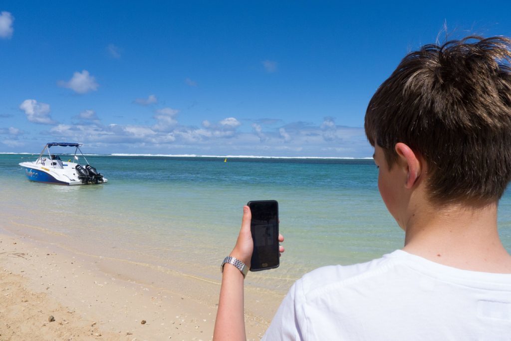 Will holding his phone in Mauritius. 