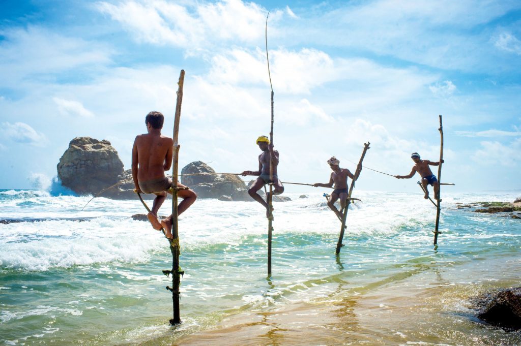 Stilt fishermen at Galle Fort Beach, Sri Lanka. 