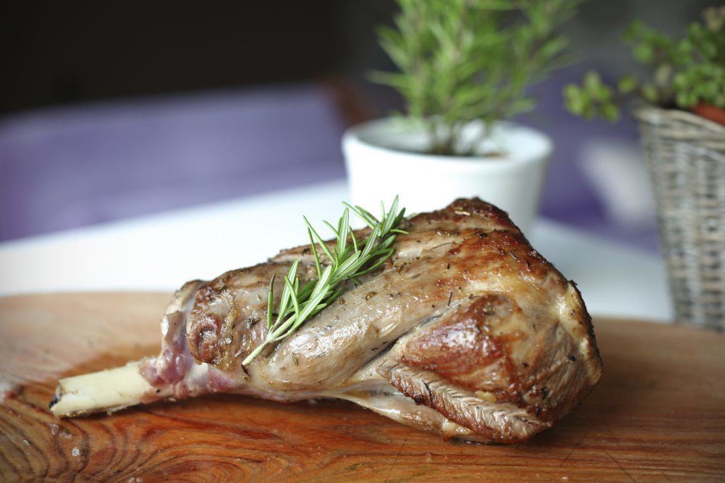 Roasted leg of lamb with rosemary on the cutting board