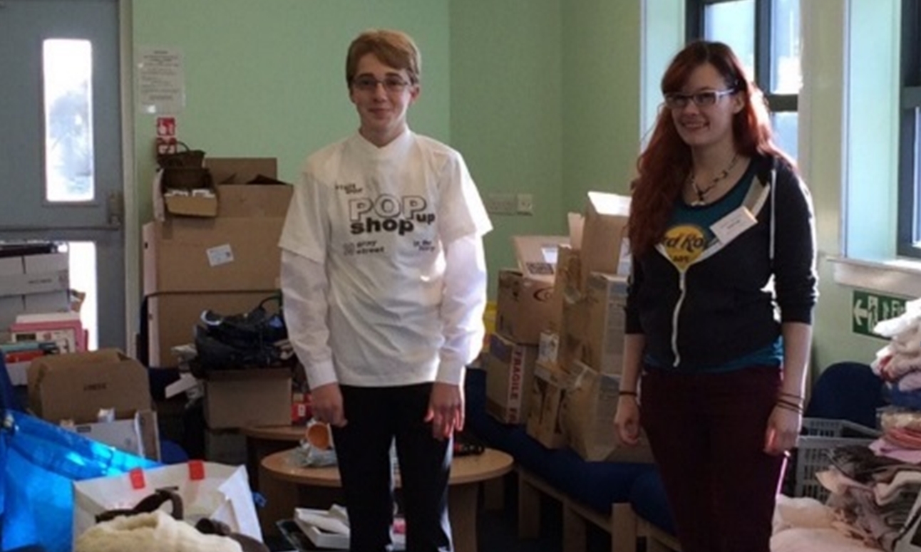 Pupils Samuel and Cora helping to sort the collection of donated goods.