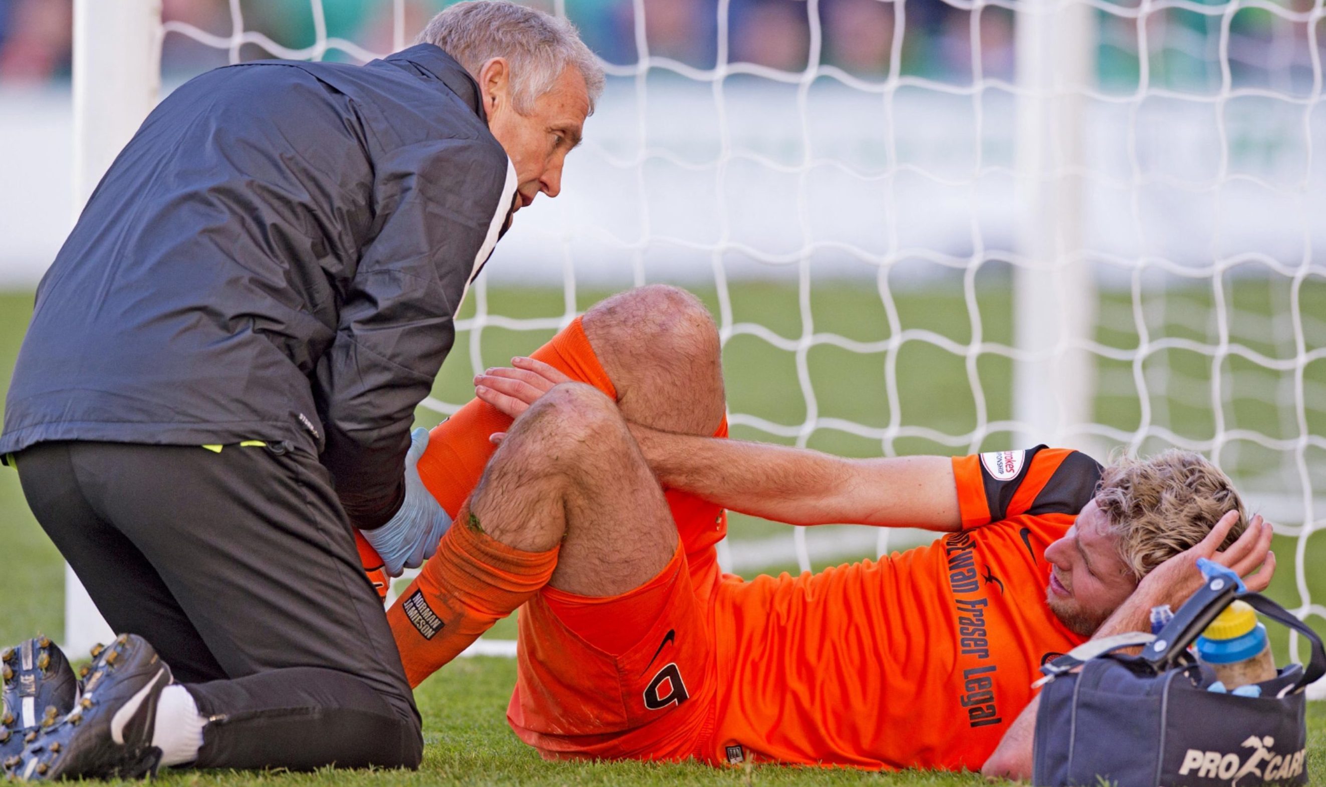 Lewis Toshney gets treatment for ankle injury during Hibs game.