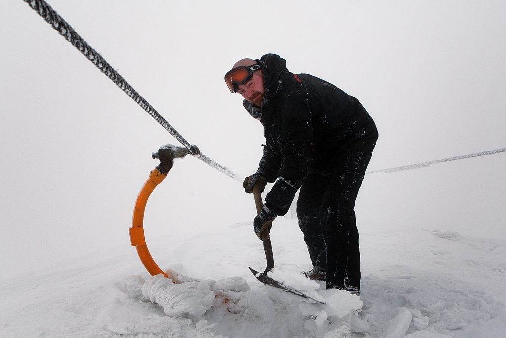 Glenshee, 2014. Graeme Davidson of the ski patrol tries to dig out a chairlift.