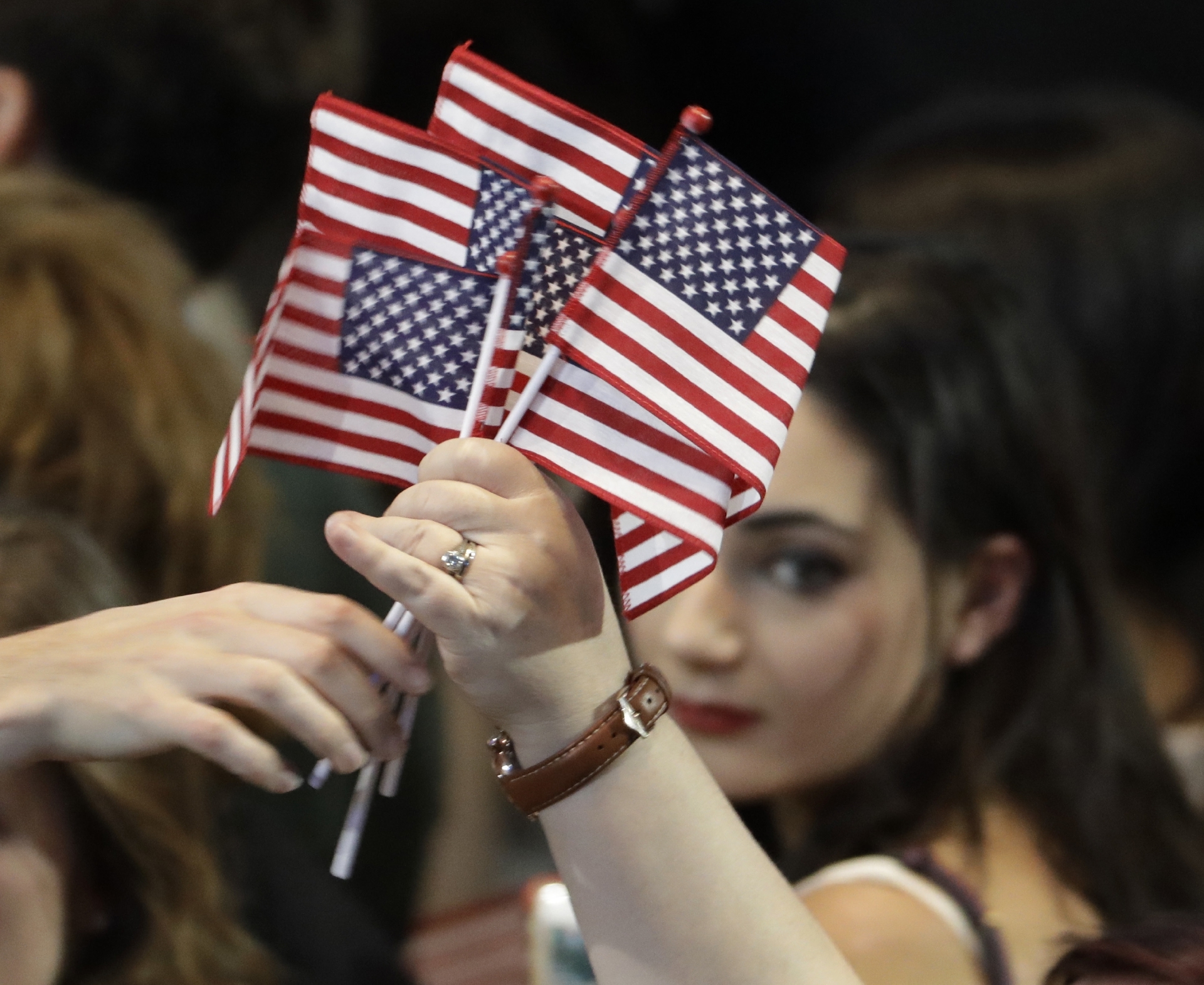 American flags are handed out at a rally.