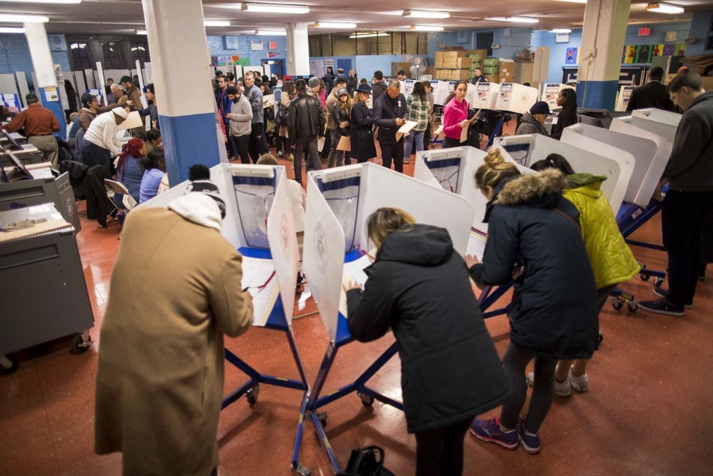 Voters fill out their forms and wait to vote at a polling station in the Brooklyn borough of New York