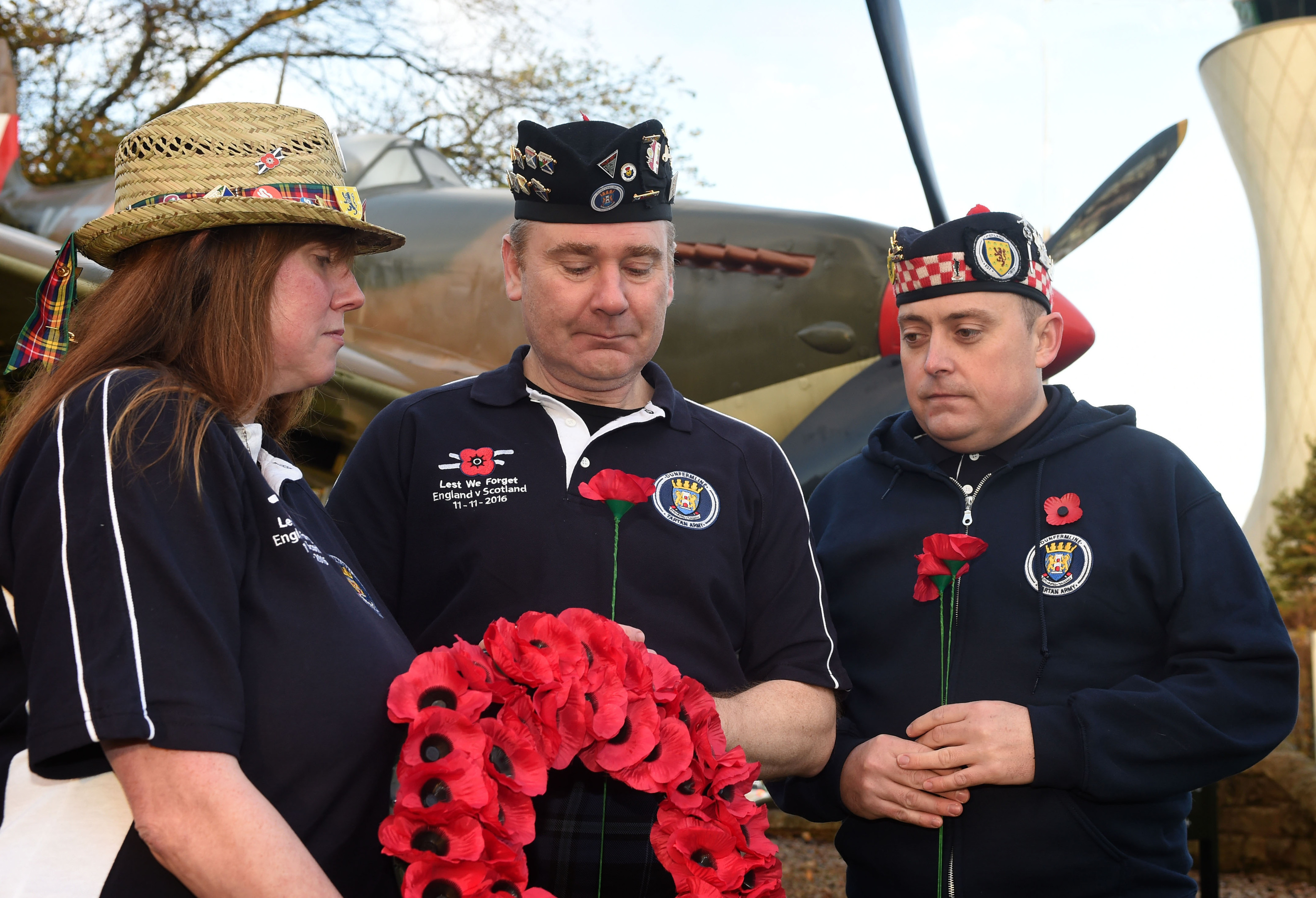 Members of the Tartan Army Jim and Audrey Ford, accompanied by Steven Avril pay their respects at the site of a WW 2 Spitfire at Edinburgh Airport.